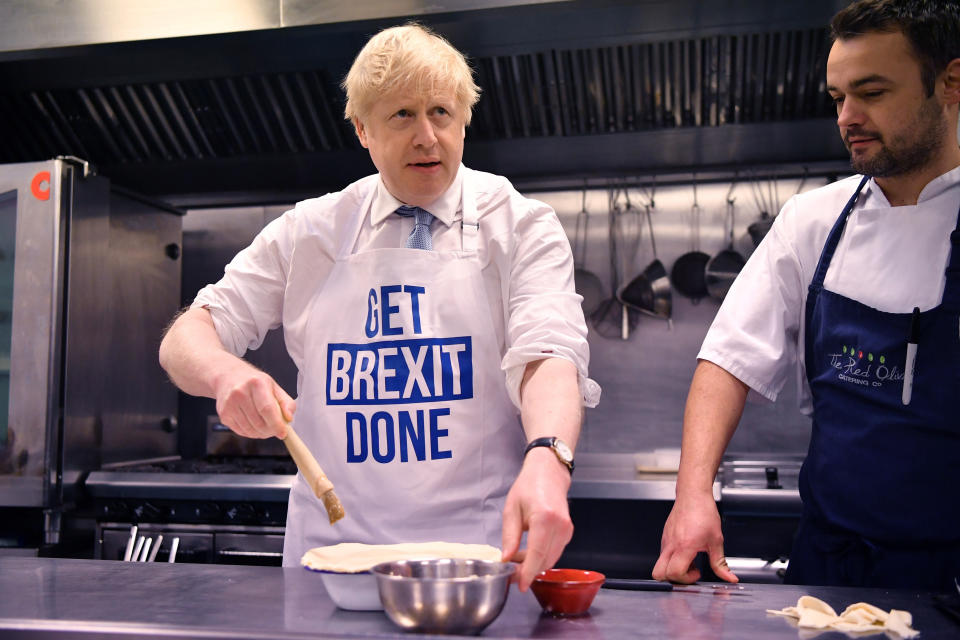 Britain's Prime Minister Boris Johnson prepares a pie at the Red Olive catering company while on the campaign trail, in Derby, England, Wednesday, Dec. 11, 2019 Britain goes to the polls on Dec. 12. (Ben Stansall/Pool Photo via AP)