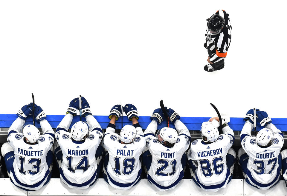 EDMONTON, ALBERTA - SEPTEMBER 13: Referee Wes McCauley #4 looks to the Tampa Bay Lightning bench as Cedric Paquette #13, Patrick Maroon #14, Ondrej Palat #18, Brayden Point #21, Nikita Kucherov #86 and Yanni Gourde #37 of the Tampa Bay Lightning look on from the bench area in the third period of Game Four of the Eastern Conference Final of the 2020 NHL Stanley Cup Playoffs between the Tampa Bay Lightning and the New York Islanders at Rogers Place on September 13, 2020 in Edmonton, Alberta. (Photo by Andy Devlin/NHLI via Getty Images)