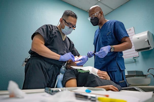 PHOTO: Air Force Maj. Rondre Baluyot, left, performs a dental exam alongside Master Sgt. Julian Blyden, on a local Guatemalan while deployed in support of Health Engagements Assistance Response Team 2022, Aug. 26, 2022, in Quetzaltenango, Guatemala. (Staff Sgt. Dustin Biven/Defense Media Activity/Army)
