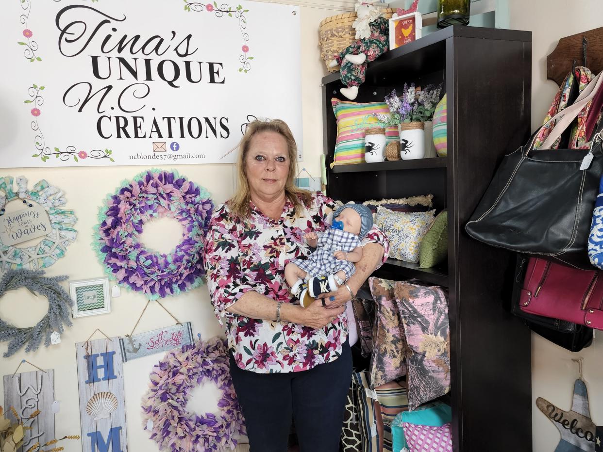Tina Summa is pictured with one of her life-like doll creations at her vendor shop located at The Treasure Trove in James City.