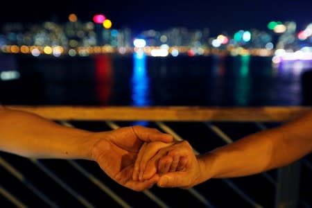 Protesters hold hands to form a human chain during a rally to call for political reforms at Tsim Sha Tsui and Hung Hom Promenade in Hong Kong