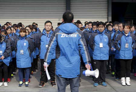 Workers listen to their line manager as he prepares them for the upcoming Singles Day shopping festival, at a sorting centre of Zhongtong (ZTO) Express, Chaoyang District, Beijing, November 8, 2015. REUTERS/Jason Lee