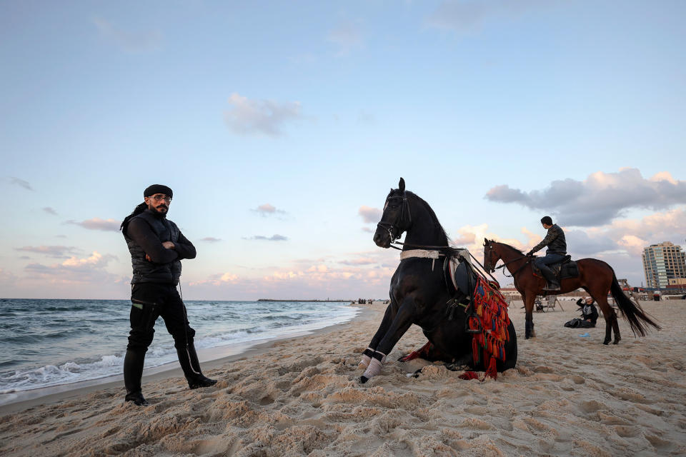 A Palestinian man and his horse take in the sunset at a beach in Gaza on Dec. 5, 2022.