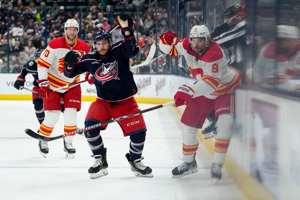Oct 20, 2023; Columbus, Ohio, USA; Columbus Blue Jackets right wing Justin Danforth (17) fights for a puck with Calgary Flames defenseman Chris Tanev (8) during the first period of the NHL hockey game at Nationwide Arena.