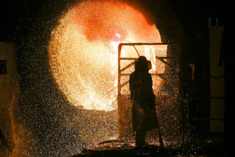 An employee in protective clothing works with a steel pouring ladle at a steel mill in Salzgitter, March 2019