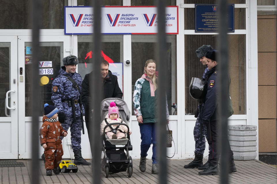 Family leave a polling station after voting during a presidential election in St. Petersburg, Russia, Saturday, March 16, 2024. Voters in Russia are heading to the polls for a presidential election that is all but certain to extend President Vladimir Putin’s rule after he clamped down on dissent. (AP Photo/Dmitri Lovetsky)