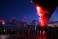 SYDNEY, AUSTRALIA - DECEMBER 31: People watch fireworks under The Sydney Harbour Bridge during New Years Eve celebrations on Sydney Harbour on December 31, 2012 in Sydney, Australia. (Photo by Brendon Thorne/Getty Images)