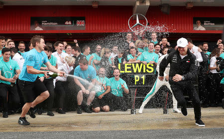 Formula One F1 - Spanish Grand Prix - Circuit de Barcelona-Catalunya, Barcelona, Spain - May 13, 2018 Mercedes’ Lewis Hamilton and Valtteri Bottas are sprayed with champagne by a member of their team as they celebrate after finishing first and second respectively REUTERS/Albert Gea