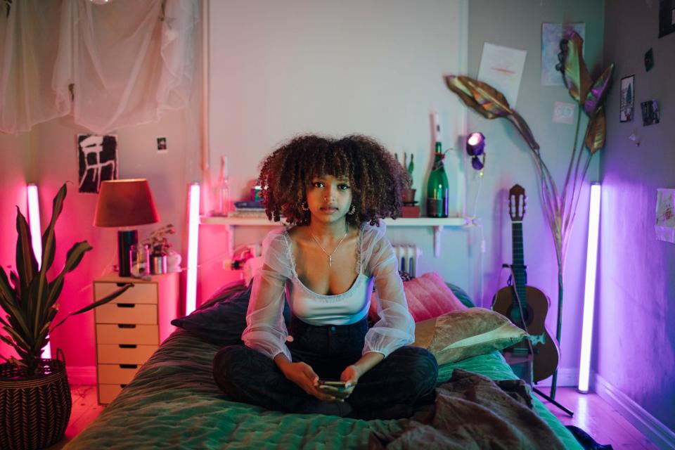 Young woman sitting in her bedroom