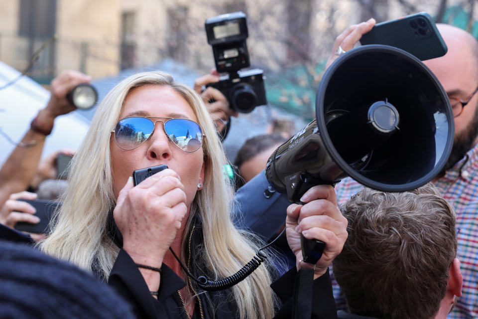 Rep. Marjorie Taylor Greene, R-Ga., speaking into an amplifier and holding a bullhorn, outside Manhattan Criminal Courthouse on Tuesday.