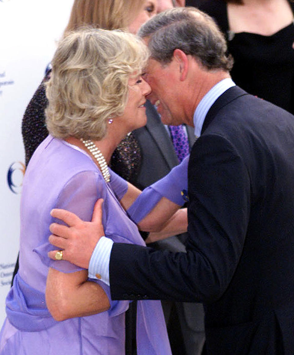 Britain's Prince Charles (R) kisses his companion Camilla Parker Bowles (L) at the National Osteoporosis Society's 15th Birthday Celebrations at Somerset House, London June 26, 2001. The party is hosted by Camilla, whose mother died of osteoperosis in 1994.    BR