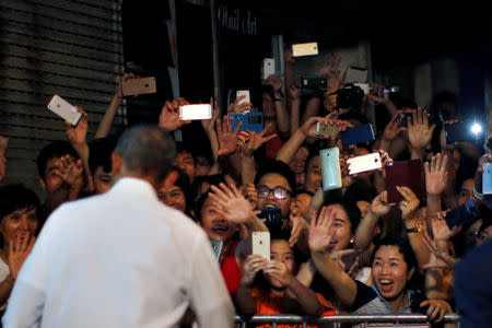 Local residents react as President Obama leaves after having a dinner with Anthony Bourdain at a restaurant in Hanoi. REUTERS/Carlos Barria