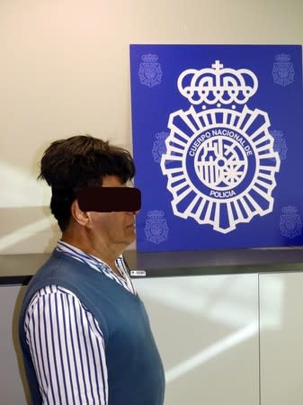 A man poses with a toupee with a drug package under it after being arrested in Barcelona