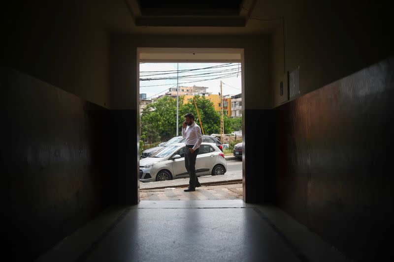 Elie Hasrouty talks on the phone as he waits for news about his father Ghassan Hasrouty, a missing silo employee, following Tuesday's blast in Beirut's port area