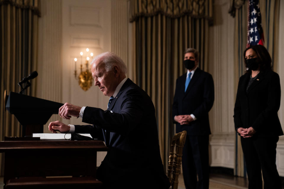 WASHINGTON, DC - JANUARY 27: U.S. President Joe Biden prepares to sign executive orders after speaking about climate change issues in the State Dining Room of the White House on January 27, 2021 in Washington, DC. President Biden signed several executive orders related to the climate change crisis on Wednesday, including one directing a pause on new oil and natural gas leases on public lands. Also pictured, left to right, Special Presidential Envoy for Climate John Kerry and U.S. Vice President Kamala Harris. (Photo by Anna Moneymaker-Pool/Getty Images)