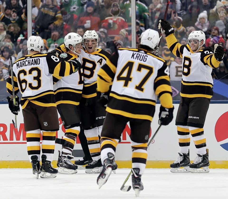 <p>
              Boston Bruins center Patrice Bergeron (37), center, celebrates with teammates after scoring his goal in the second period of the NHL Winter Classic hockey game against the Chicago Blackhawks at Notre Dame Stadium, Tuesday, Jan. 1, 2019, in South Bend, Ind. (AP Photo/Nam Y. Huh)
            </p>