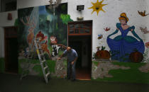 School director Salvador Corral works on restoration projects at La casa del Colibri kindergarten, which remains closed due to the new cornavirus pandemic, in Mexico City, Tuesday, April 20, 2021. The Mexican government began giving teachers in five other states the single-dose CanSino COVID-19 vaccine to speed up their return to the classroom before the end of the school year in July. (AP Photo/Marco Ugarte)