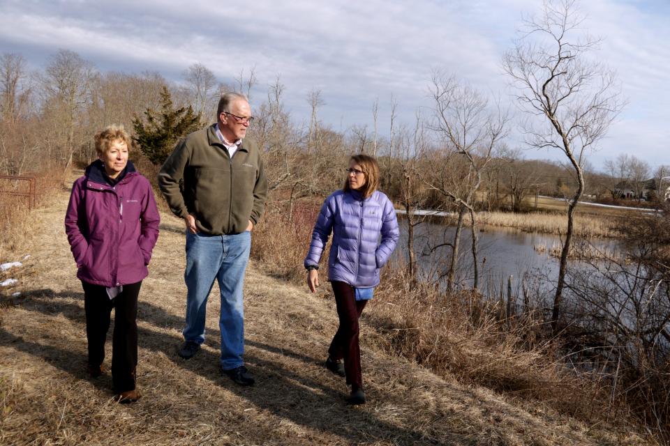 Pam Marchand, left, and Ken Booth of the Bristol County Water Authority and Wenley Ferguson of Save The Bay cross the upper dam on the Kickemuit River in Warren in 2019.