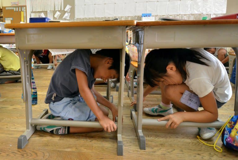 Elementary school children take cover under their desks in an earthquake drill at a school in Tokyo on September 2. The battered nuclear plant at Fukushima, where radioactive water is leaking into the ocean, hangs over Tokyo's bid for the 2020 Olympic Games