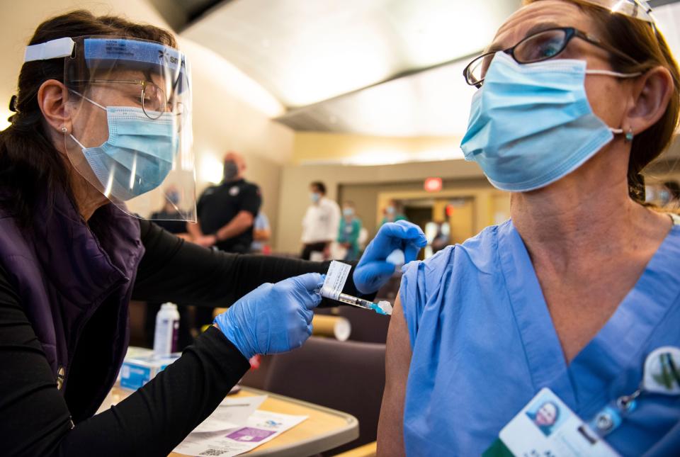 Health care workers receive the first doses of the Pfizer COVID-19 vaccine at the University of Vermont Medical Center on Tuesday, Dec. 15, 2020. 