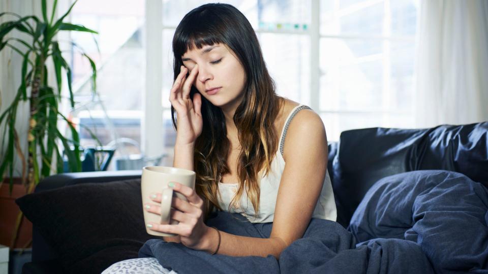 woman looking tired sitting on sofa