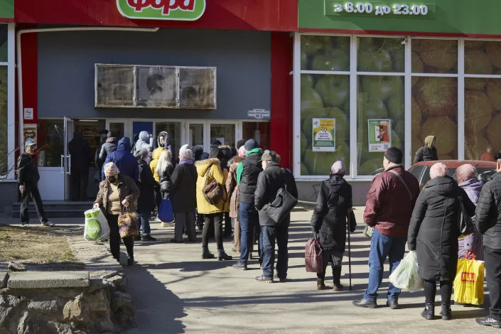 Local residents line up outside a supermarket. 