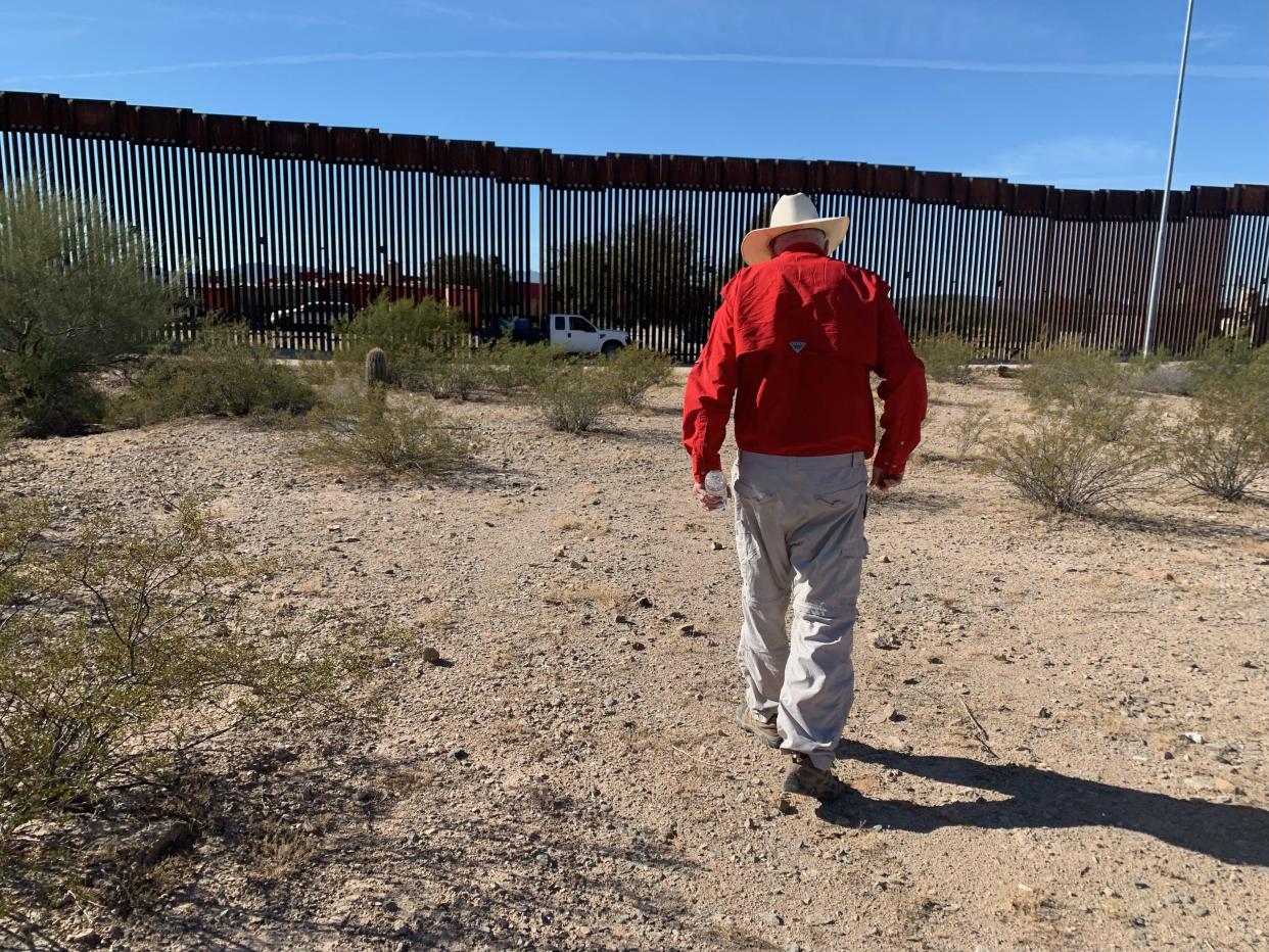 Tom Wingo, a volunteer with Humane Borders, a humanitarian aid nonprofit, approaches a welder from the Border Patrol who watches over a section of the 30-foot bollard fence that was cut down by human smugglers on November 1, 2023.