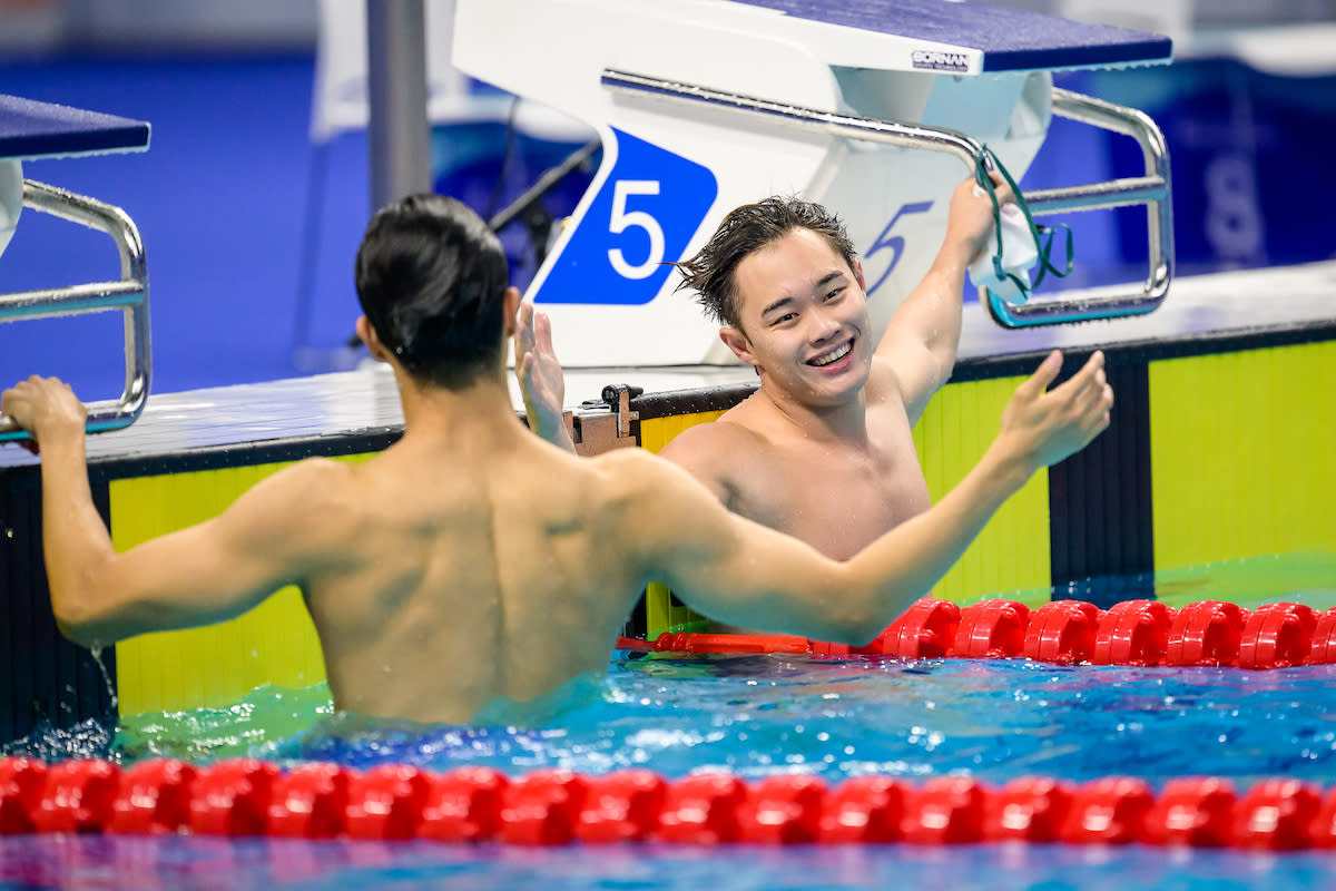 Singapore swimmer Teong Tzen Wei (right) congratulates South Korea winner Baek In-chul after coming in second in the men's 50m butterfly final at the 2023 Hangzhou Asian Games (PHOTO: Sport Singapore/Andy Chua)