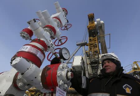 FILE PHOTO: A worker checks a pressure gauge at an oil pumping station owned by Rosneft in the Suzunskoye oil field, near Krasnoyarsk, Russia, March 26, 2015. REUTERS/Sergei Karpukhin/File Photo