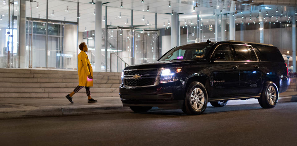 Person approaching a black SUV Lyft at night