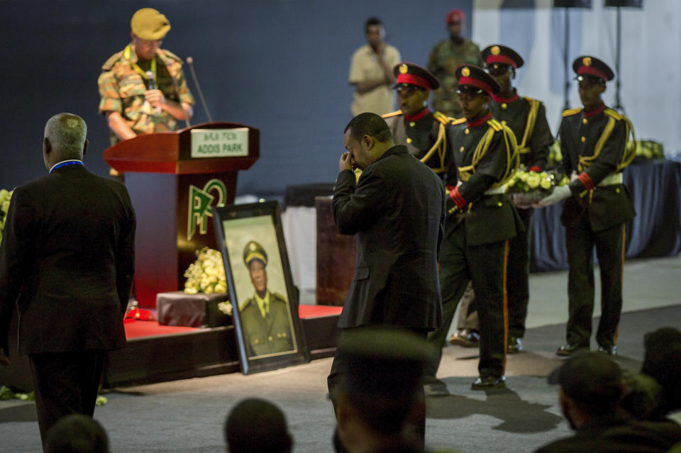 Ethiopia's Prime Minister Abiy Ahmed, center, attends a state ceremony for assassinated army chief Gen. Seare Mekonnen, at the Millennium Hall in the capital Addis Ababa, Ethiopia Tuesday, June 25, 2019. Ethiopia's Prime Minister Abiy Ahmed sobbed openly at the service Tuesday for the military chief who was assassinated by his own bodyguard over the weekend. (AP Photo/Mulugeta Ayene)