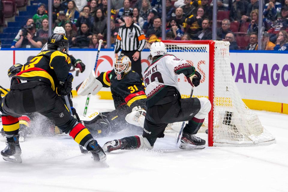 Arizona Coyotes forward Logan Cooley (92) scores the game-winning goal in overtime on Vancouver Canucks goalie Arturs Silvos (31) at Rogers Arena in Vancouver on April 10, 2024. Arizona won 4-3 in overtime.