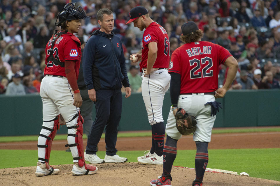 Cleveland Guardians starting pitcher Tanner Bibee, second from right, is checked by a member of the team's medical staff after being hit on the foot by Texas Rangers' Leody Taveras (not shown), as Bo Naylor, left and Josh Naylor, right look on during the fifth inning of a baseball game in Cleveland Saturday, Sept. 16, 2023. Bibee left the game in the sixth inning because of the injury. (AP Photo/Phil Long)