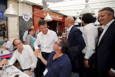 French Prime Minister Manuel Valls (C) greets guests at a restaurant during the Socialist Party's "Universite d'ete" summer meeting in La Rochelle, France, August 29, 2015. REUTERS/Stephane Mahe