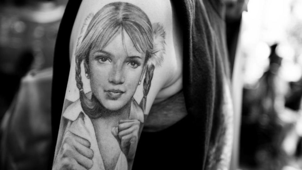 Un tatuaje de Britney Spears en el brazo de un fanático de la artista