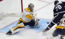 Nashville Predators goaltender Kevin Lankinen, left, looks to stop a shot by Colorado Avalanche left wing Miles Wood during the third period of an NHL hockey game Saturday, March 30, 2024, in Denver. (AP Photo/David Zalubowski)