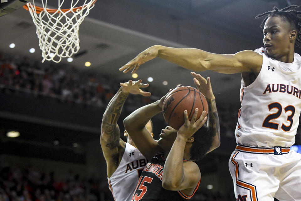 Auburn guard J'Von McCormick (5) and forward Isaac Okoro (23) block a shot by Georgia guard Sahvir Wheeler (15) during the first half of an NCAA college basketball game Saturday, Jan. 11, 2020, in Auburn, Ala. (AP Photo/Julie Bennett)