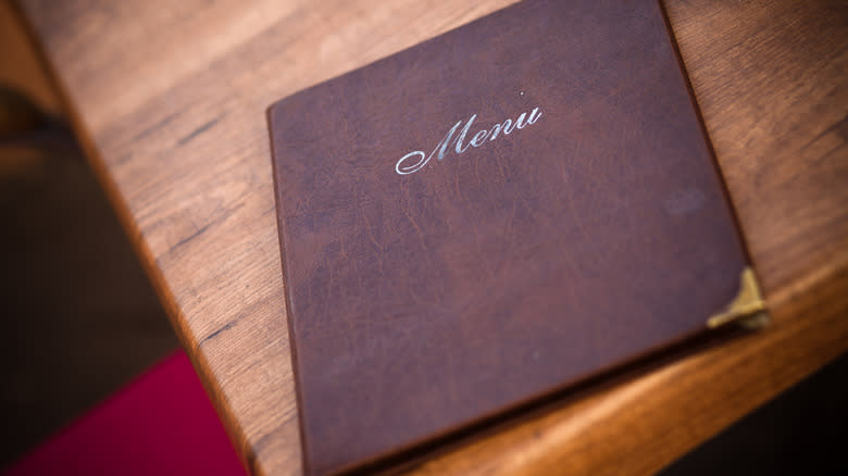 Leather-bound menu on wooden table