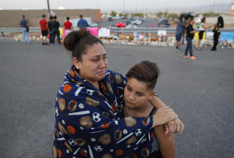 FILE - In this Aug. 5, 2019, file photo, Clarissa Hernandez holds Ezra Magallanes as they speak with the media at a makeshift memorial for victims of a mass shooting at a shopping complex in El Paso, Texas. The two mass shootings and a presidential tweet put a spotlight on the idea of “domestic terrorism,” adding momentum to a debate about whether such attacks should be classified and tried in the same way as crimes against America by foreign terrorist groups and their supporters. (AP Photo/John Locher, File)