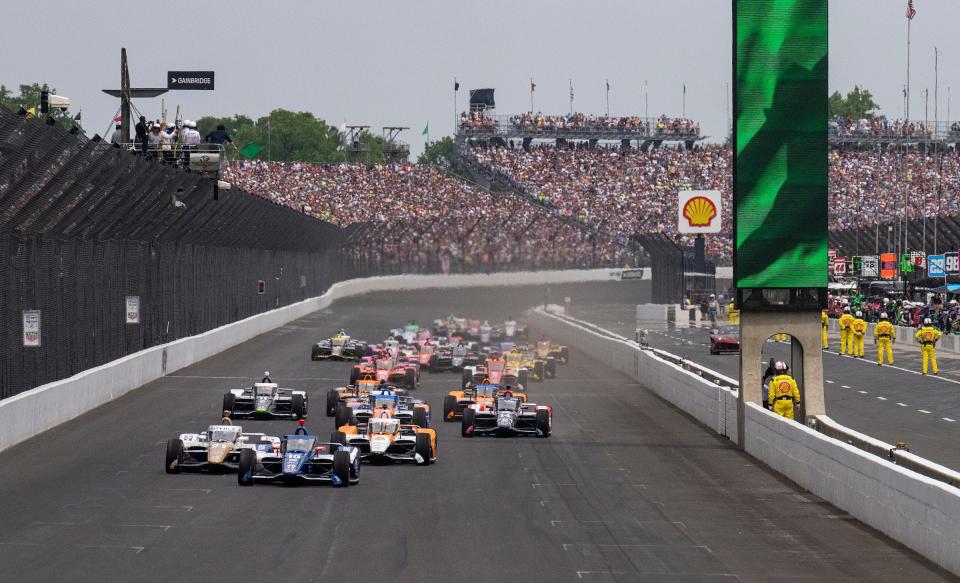 IndyCars drive in a grid formation as the green flag signals the start of the 107th Indianapolis 500 on Sunday, May 28, 2023, at Indianapolis Motor Speedway. 