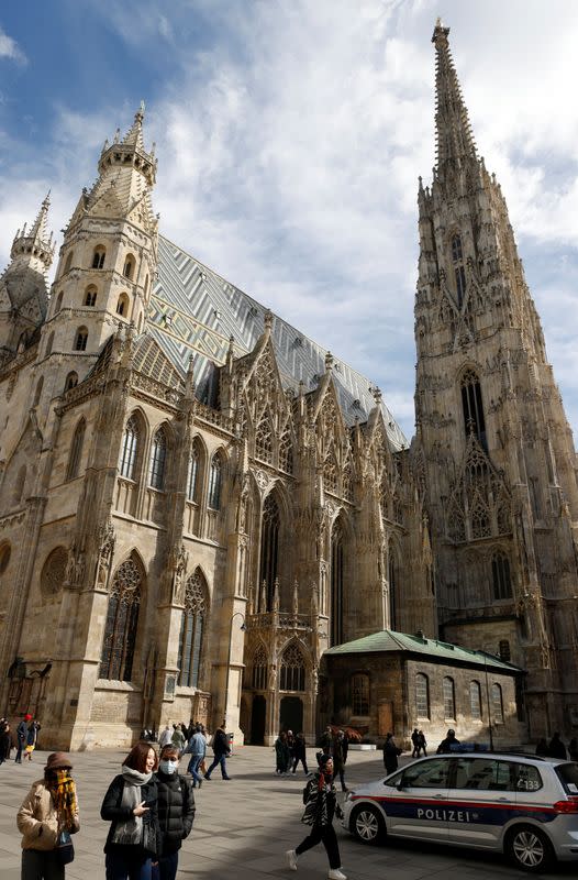 An Austrian police car passes St. Stephens cathedral in Vienna