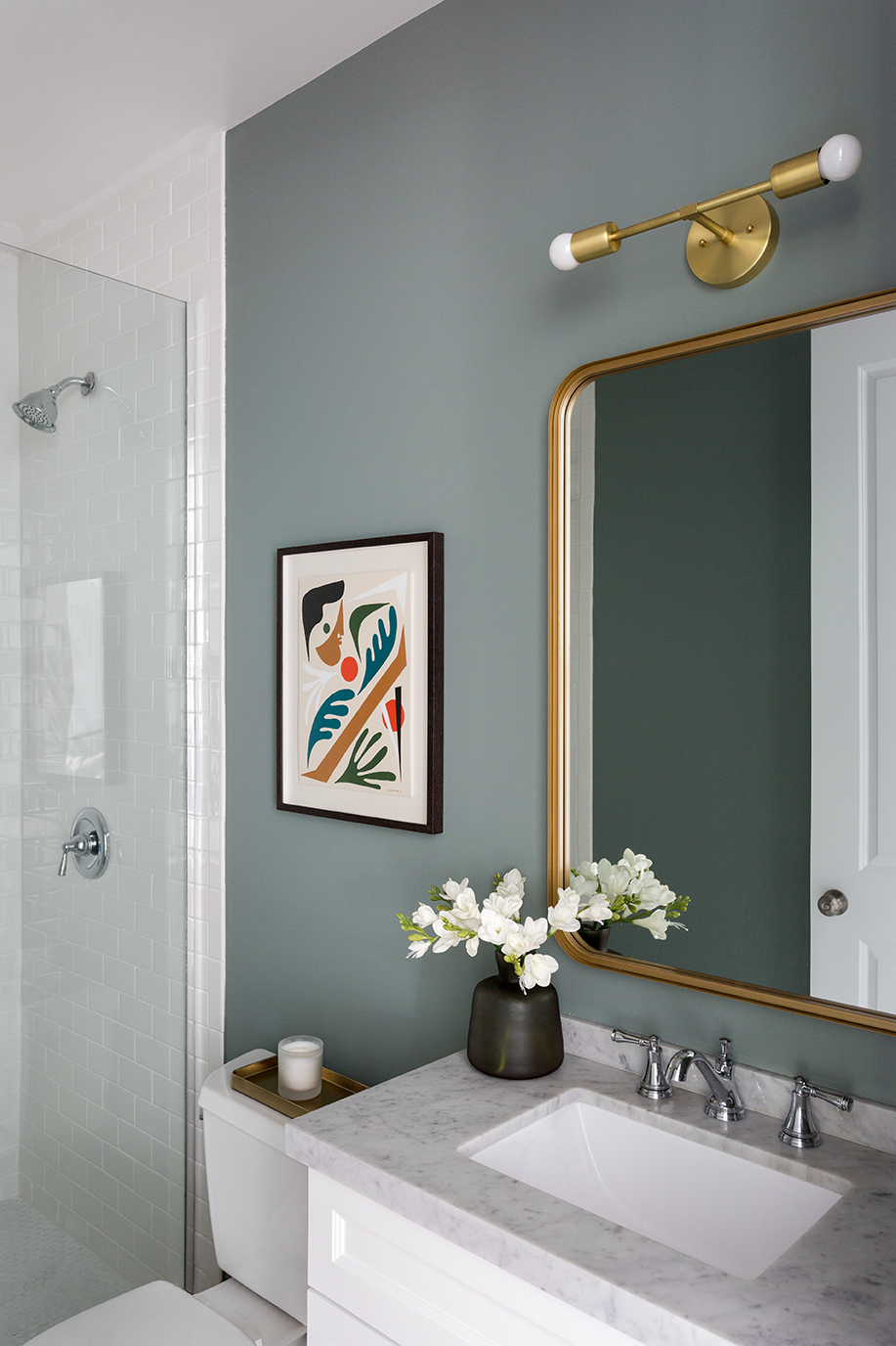 Bathroom with matte green wall paint and light green mirrors