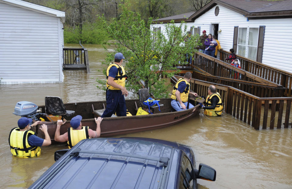 Firefighters rescue a family from their home, surrounded by floodwaters, in a mobile home park in Pelham, Ala., on Monday, April 6, 2014. Overnight storms dumped torrential rains in central Alabama, causing flooding across a wide area. (AP Photo/Jay Reeves)