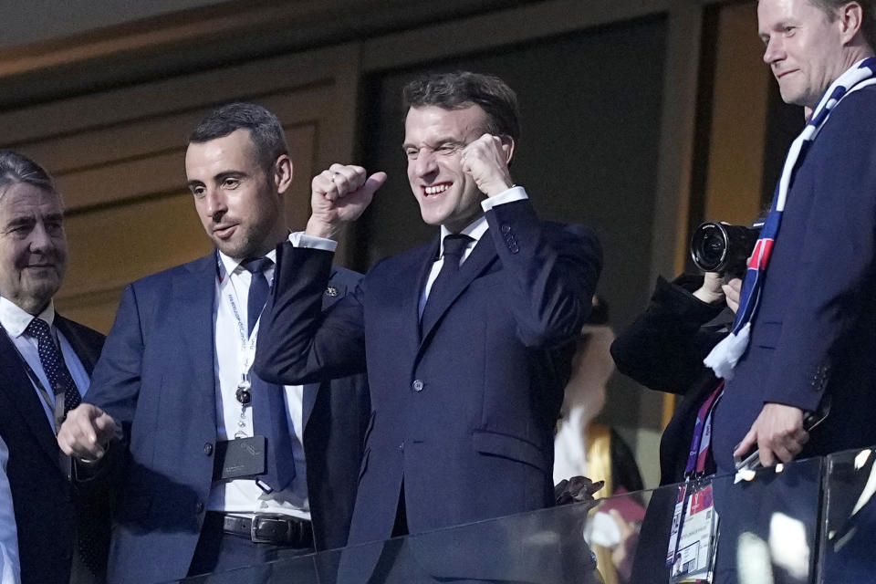 France's President Emmanuel Macron, center, gestures as he arrives on the tribune ahead of the World Cup final soccer match between Argentina and France at the Lusail Stadium in Lusail, Qatar, Sunday, Dec. 18, 2022. (AP Photo/Martin Meissner)