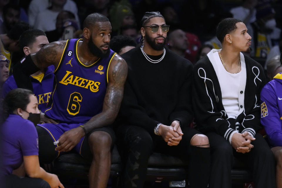 Los Angeles Lakers forward LeBron James, left, sits next to injured teammates Anthony Davis, center, and Juan Toscano-Anderson during the first half of the team's NBA basketball game against the Charlotte Hornets on Friday, Dec. 23, 2022, in Los Angeles. (AP Photo/Marcio Jose Sanchez)