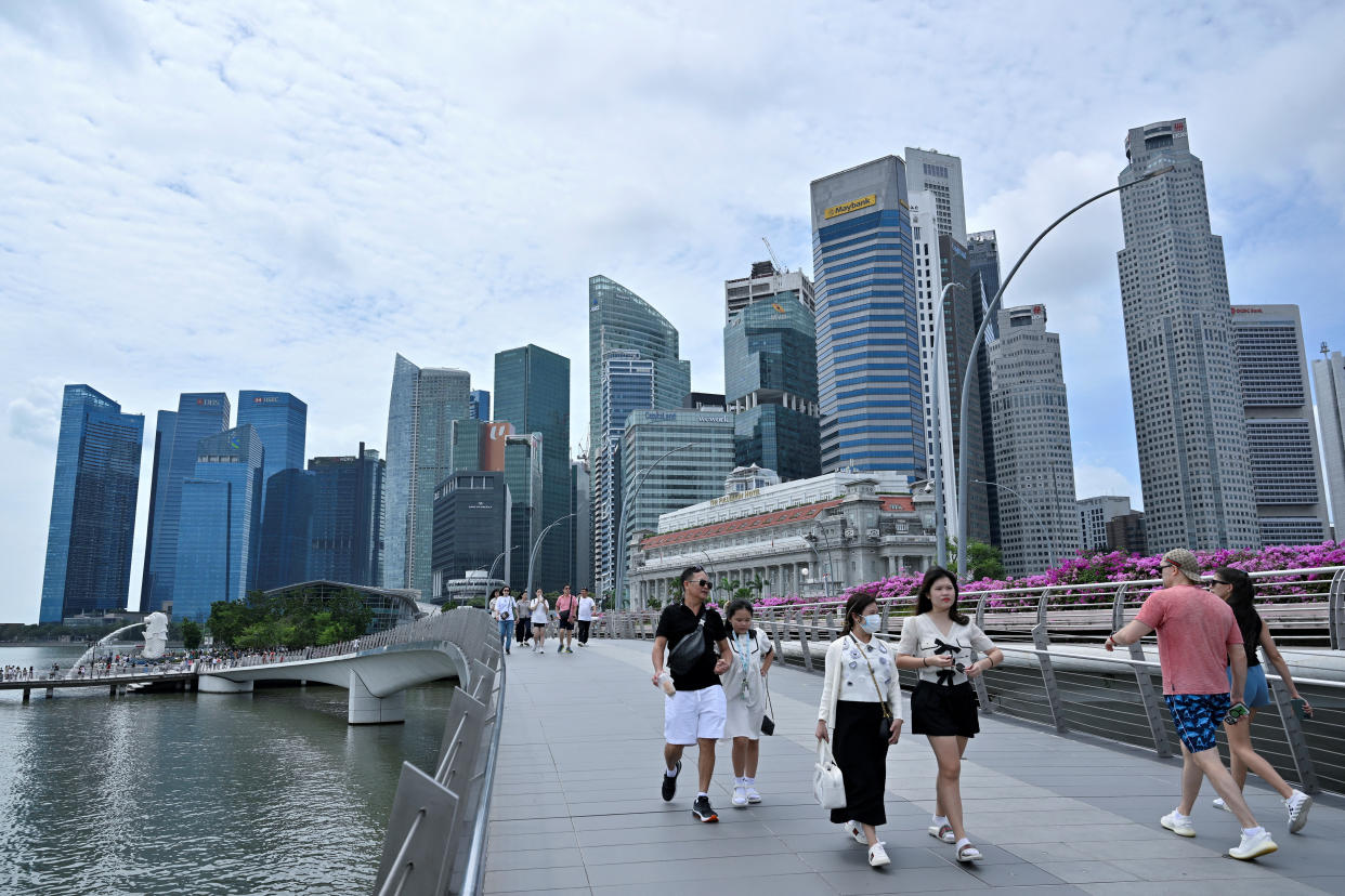 People walking with the Central Business District skyline in Singapore in the background.