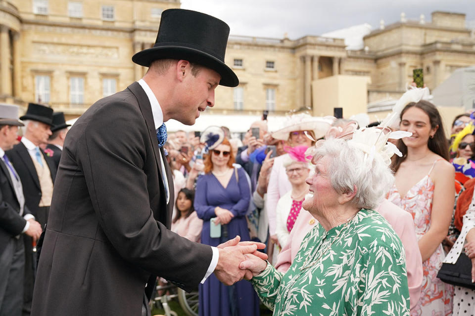 Prince William greets a royal fan during a garden party