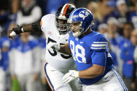 FILE - BYU defensive lineman Gabe Summers (98) rushes the passer as Virginia center Olusegun Oluwatimi (55) tries to block him in the first half durning an NCAA college football game against Virginia, Saturday, Oct. 30, 2021, in Provo, Utah. Oluwatimi was one of three finalists in 2021 for the Rimington Trophy that goes annually to college football’s top center. He now heads to Michigan, which won the Joe Moore Award last season for having college football’s top offensive line. (AP Photo/George Frey, File)