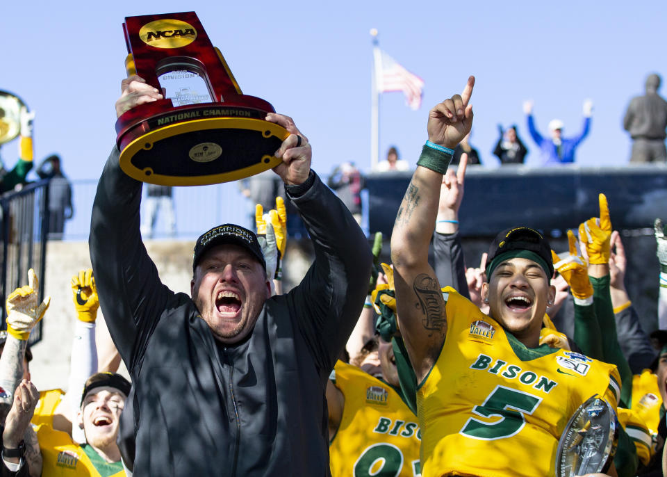 North Dakota State head coach Matt Entz raises the trophy alongside quarterback Trey Lance (5) as they celebrate after beating James Madison 28-20 in the FCS championship game in Frisco, Texas. (AP)