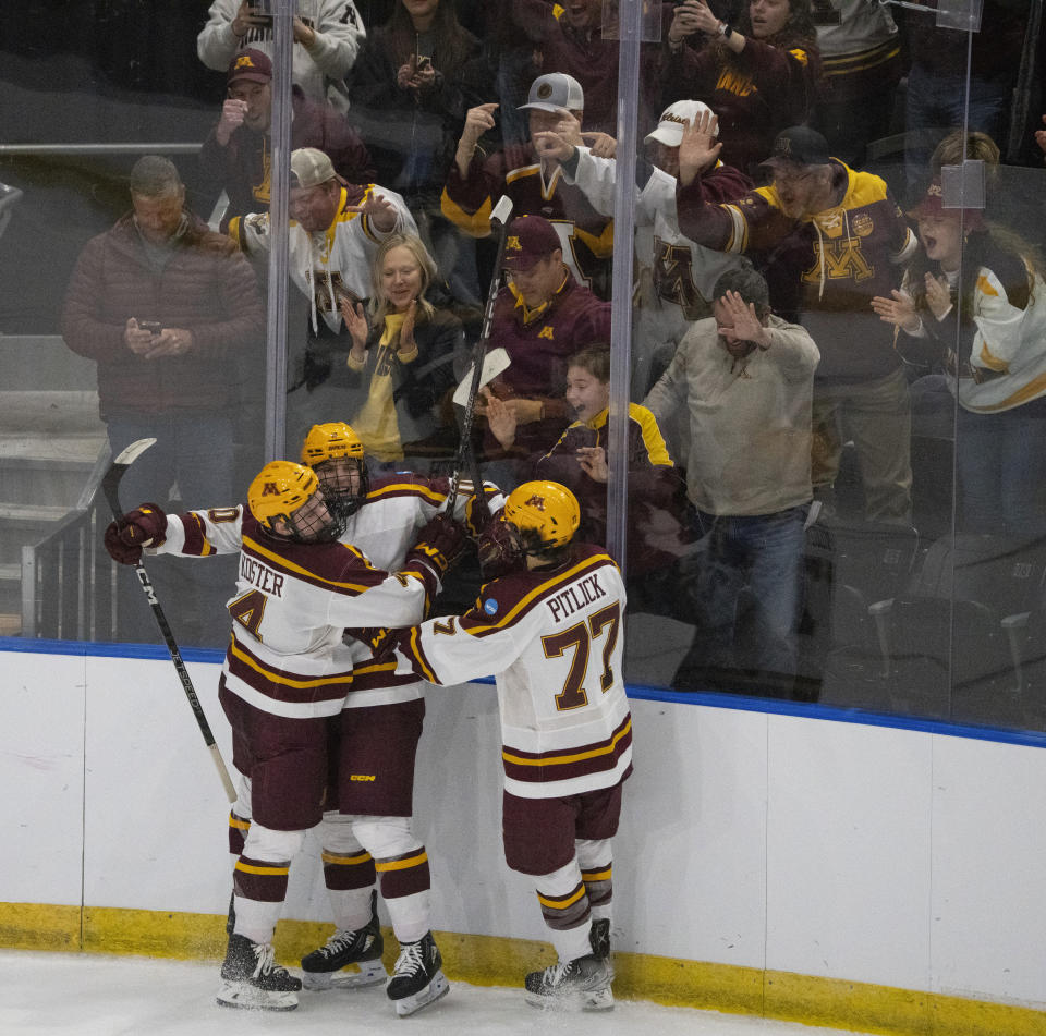 Minnesota forward Connor Kurth (10) is congratulated by defenseman Mike Koster (4) and forward Rhett Pitlick (77) after scoring the go-ahead goal in the second period of an NCAA Division I men's college hockey championship first-round game Thursday, March 23, 2023, in Fargo, N.D. (Jeff Wheeler/Star Tribune via AP)